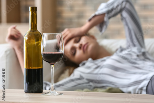 Fotomural Glass and bottle of wine on table of drunk woman