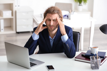 Poster - Young businessman suffering from headache in office