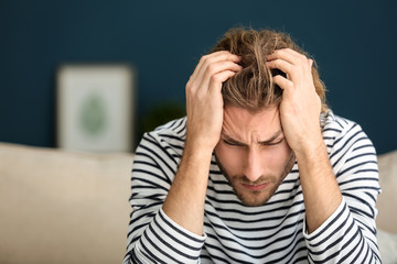 Poster - Young man suffering from headache at home