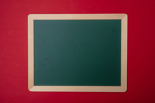 Green Blank Empty Chalkboard With Wooden Frame, Red Wall Background, Copy Space