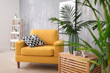 Green tropical leaves in interior of living room