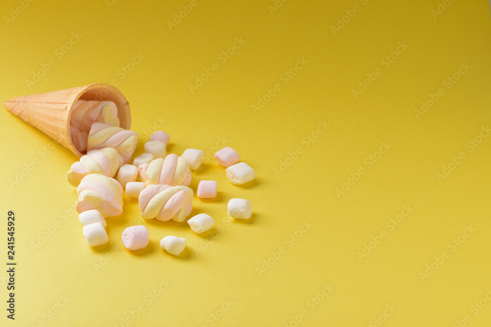 Tasty marshmallows with wafer cone on color background