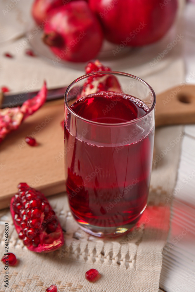 Glass of tasty pomegranate juice on table