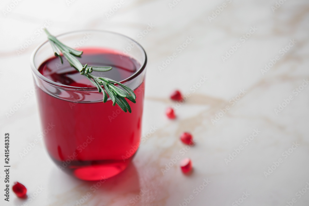Glass of tasty pomegranate juice on table