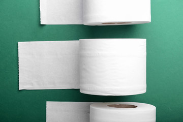 Rolls of toilet paper on color background