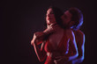 © Pixel-Shot - Passionate young couple on dark background