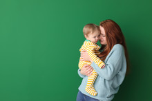Portrait Of Happy Mother With Her Little Baby On Color Background