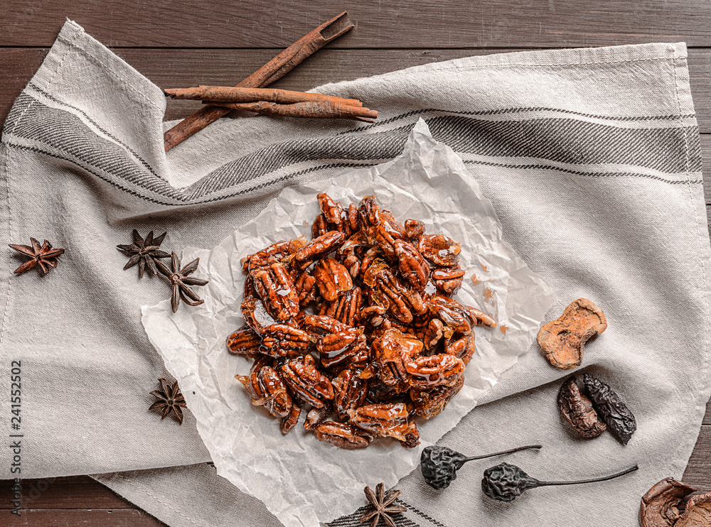Tasty candied pecan nuts on wooden table