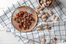 Plate With Candied Pecan Nuts On White Table