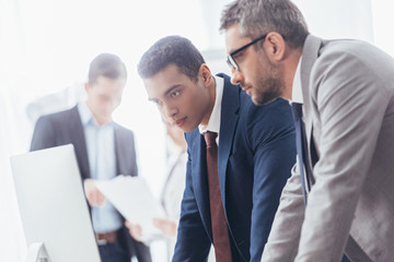 Wall Mural - focused serious businessmen working with desktop computer in office