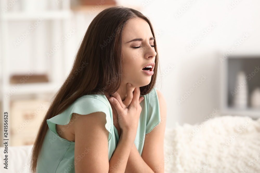 Young woman having asthma attack at home
