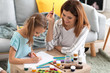 © Pixel-Shot - Happy mother with daughter painting at home