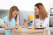 © Pixel-Shot - Happy mother with daughter painting at home