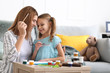 © Pixel-Shot - Happy mother with daughter painting at home