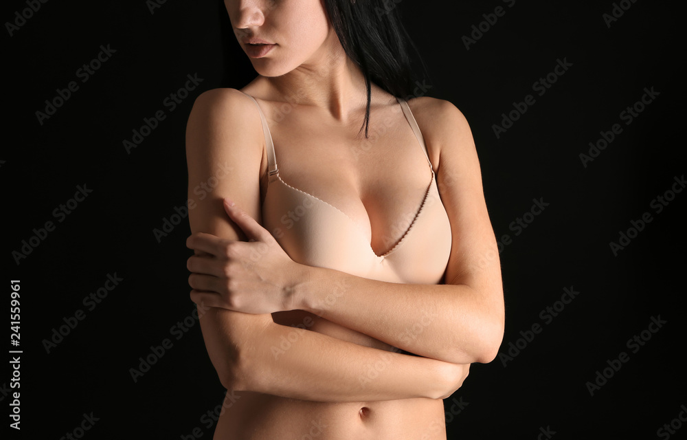 Young woman with beautiful breast on dark background