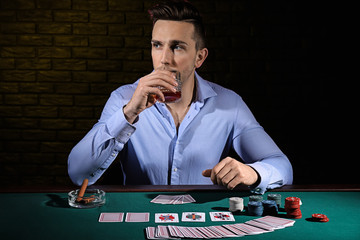 Handsome male player at table in casino