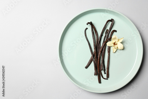Cuadros en Lienzo Plate with aromatic vanilla sticks on white background