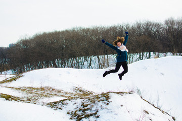 girl in winter stands on a hill with his hands up. concept of freedom or victory