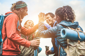 Group of happy trekkers stacking hands outdoor - Focus on hands