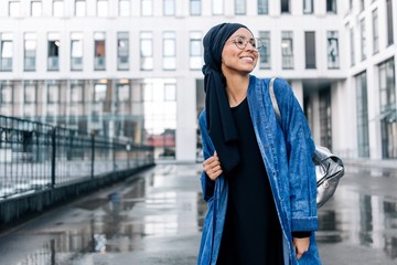 Beautiful young girl in hijab traveling around the city walking down the street. Muslim contemporary culture