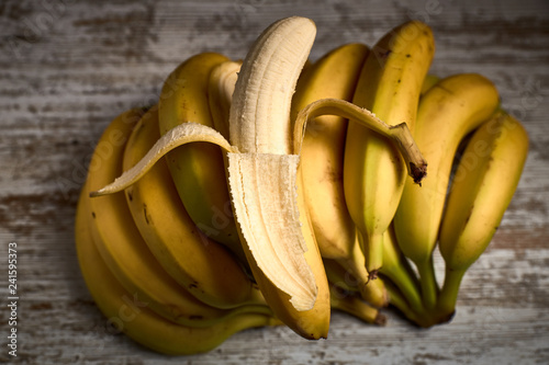 Fotografía bunch of tasty ripe yellow bananas on a light wooden board
