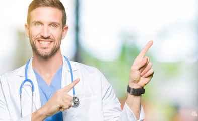 Handsome doctor man wearing medical uniform over isolated background smiling and looking at the camera pointing with two hands and fingers to the side.