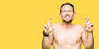 © Krakenimages.com - Handsome shirtless man showing nude chest smiling crossing fingers with hope and eyes closed. Luck and superstitious concept.
