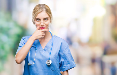 Poster - Young beautiful blonde doctor surgeon nurse woman over isolated background looking confident at the camera with smile with crossed arms and hand raised on chin. Thinking positive.