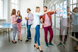 © rh2010 - Young team of coworkers dressed casually talking together near the glass wall with some statistics and stickers in the office
