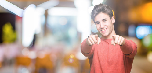 Young handsome man over isolated background Pointing to you and the camera with fingers, smiling positive and cheerful