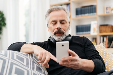 Senior man typing a text message on a mobile