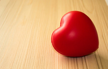 Big red heart on light wooden table isolated on blurred background. Love concept. Happy Valentine's day.