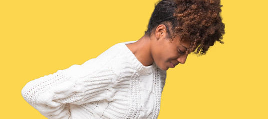 Wall Mural - Beautiful young african american woman wearing winter sweater over isolated background Suffering of backache, touching back with hand, muscular pain