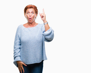 Canvas Print - Atrractive senior caucasian redhead woman wearing winter sweater over isolated background pointing finger up with successful idea. Exited and happy. Number one.