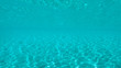 © helivideo - UNDERWATER: Bright tropical sun rays shine through the surface of blue ocean.
