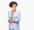 © Krakenimages.com - Young afro american woman over isolated background looking stressed and nervous with hands on mouth biting nails. Anxiety problem.