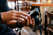 © Cavan Images - Man's hand holding digital camera in cafe