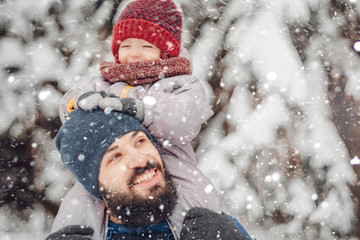 Canvas Print - happy father and baby son having fun under winter snow, holiday season.