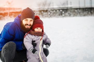 Wall Mural - Father and son enjoying winter. father and baby on winter holidays walking in a snowy park.