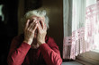 Emotions of elderly woman sitting at the table. 90 year old.