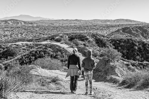 Fotografia, Obraz Mother and daughter stand above a city in mountains