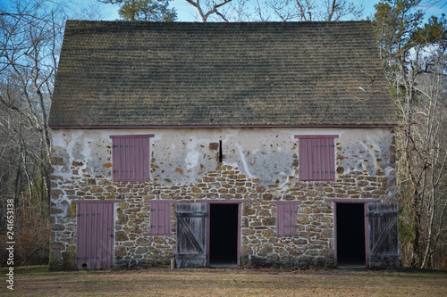 Foto Front facade of historic farm house with stone walls