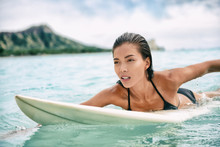 Surfing Asian Woman Surfer Girl On Surf Lesson In Hawaii Paddling On Surfboard In Ocean. Sexy Sports Athlete Training In Water. Watersport Active Lifestyle.