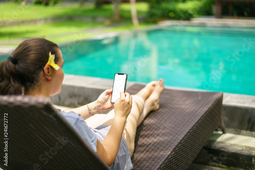 Woman Sitting In Deck Chair Tropical Pool Holding The Black