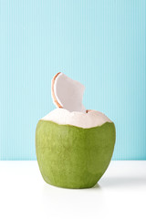 Wall Mural - Fresh coconut on a pastel blue background, summer vibes concept