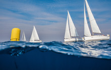 Underwater View On Sailing Boats With Yellow Buoy Racing At Open Sea