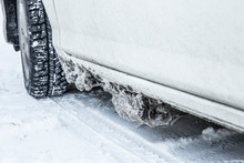Detail View Of Frozen Salt, Snow And Ice Chunks Stuck Under Car Body, Causes Rust And Corrosion In The Winter Outdoors.