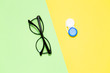 Flat lay composition with contact lenses and glasses on color background