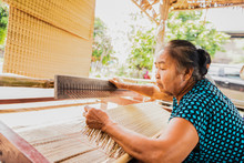 Asian Woman Weaving Typical Thai Straw Mat From Dry Papyrus