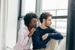 © alfa27 - Interracial married couple embrace affectionately at home interior, sitting near large window, feel support and emotional resource from each other, have close relationship.